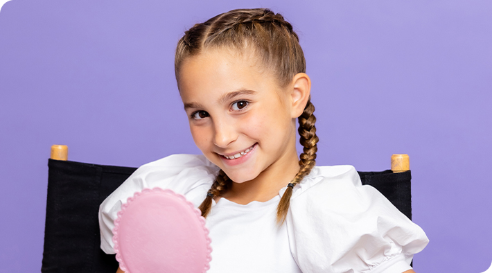 A girl with braided hair smiling.