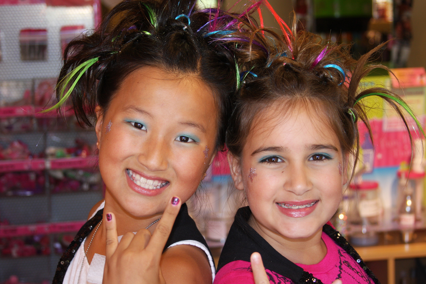 Two girls posing with rockstar hairstyles in kids hair salon