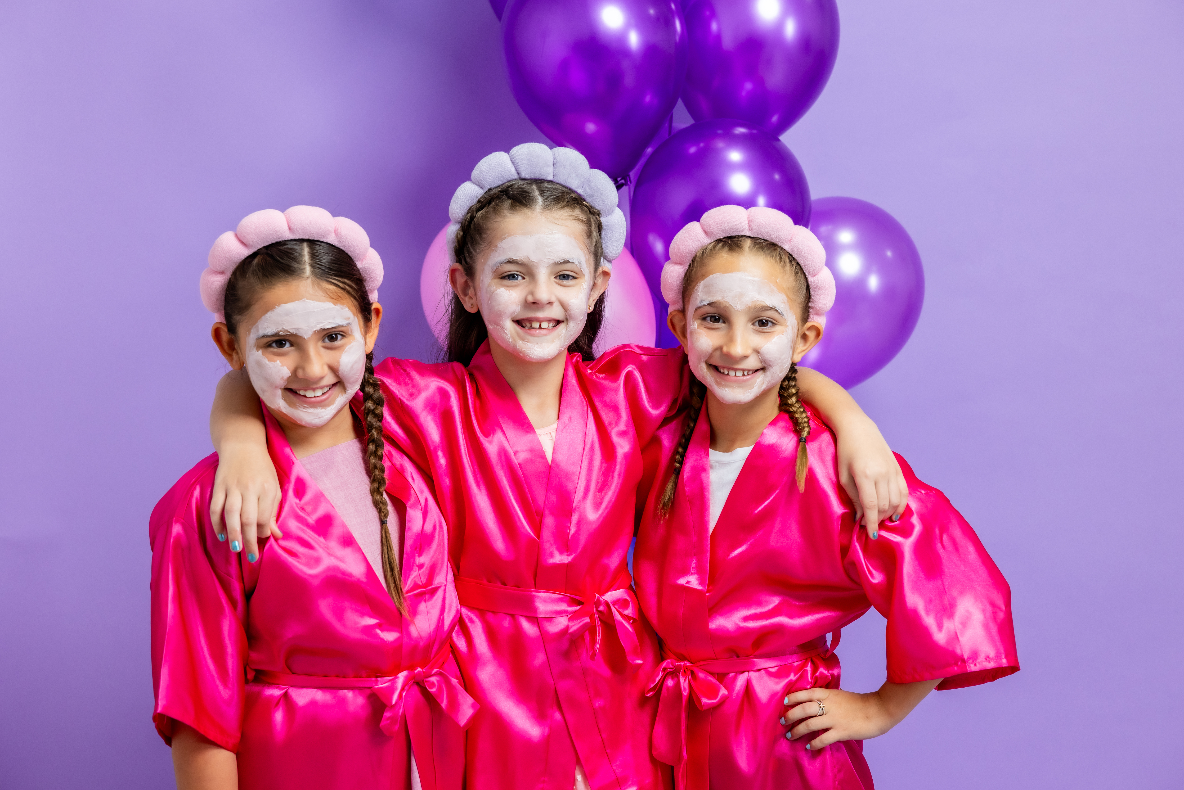 3 young girls in pink robes and facemasks