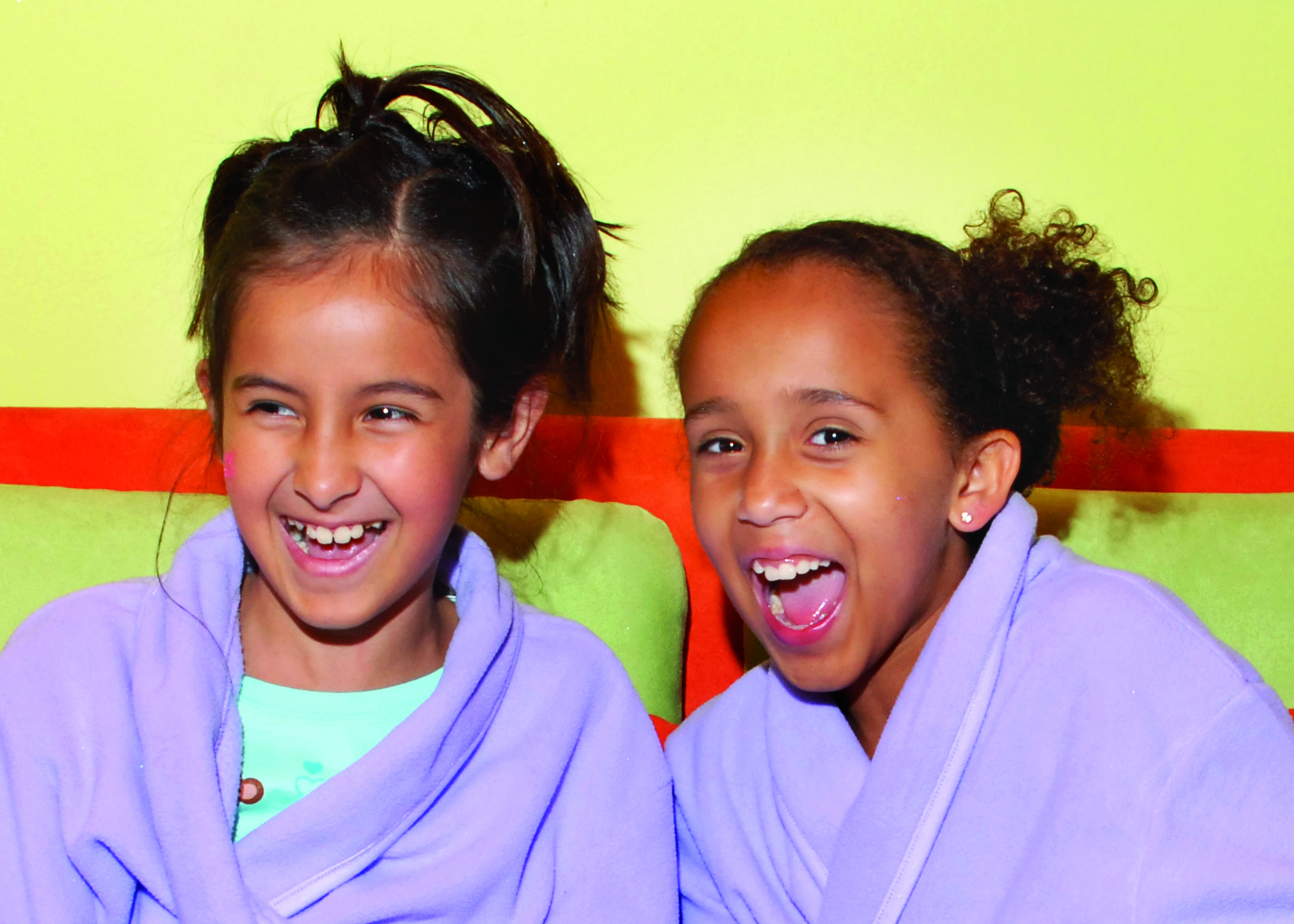 Two girls wearing robes and laughing at kids spa in Plano