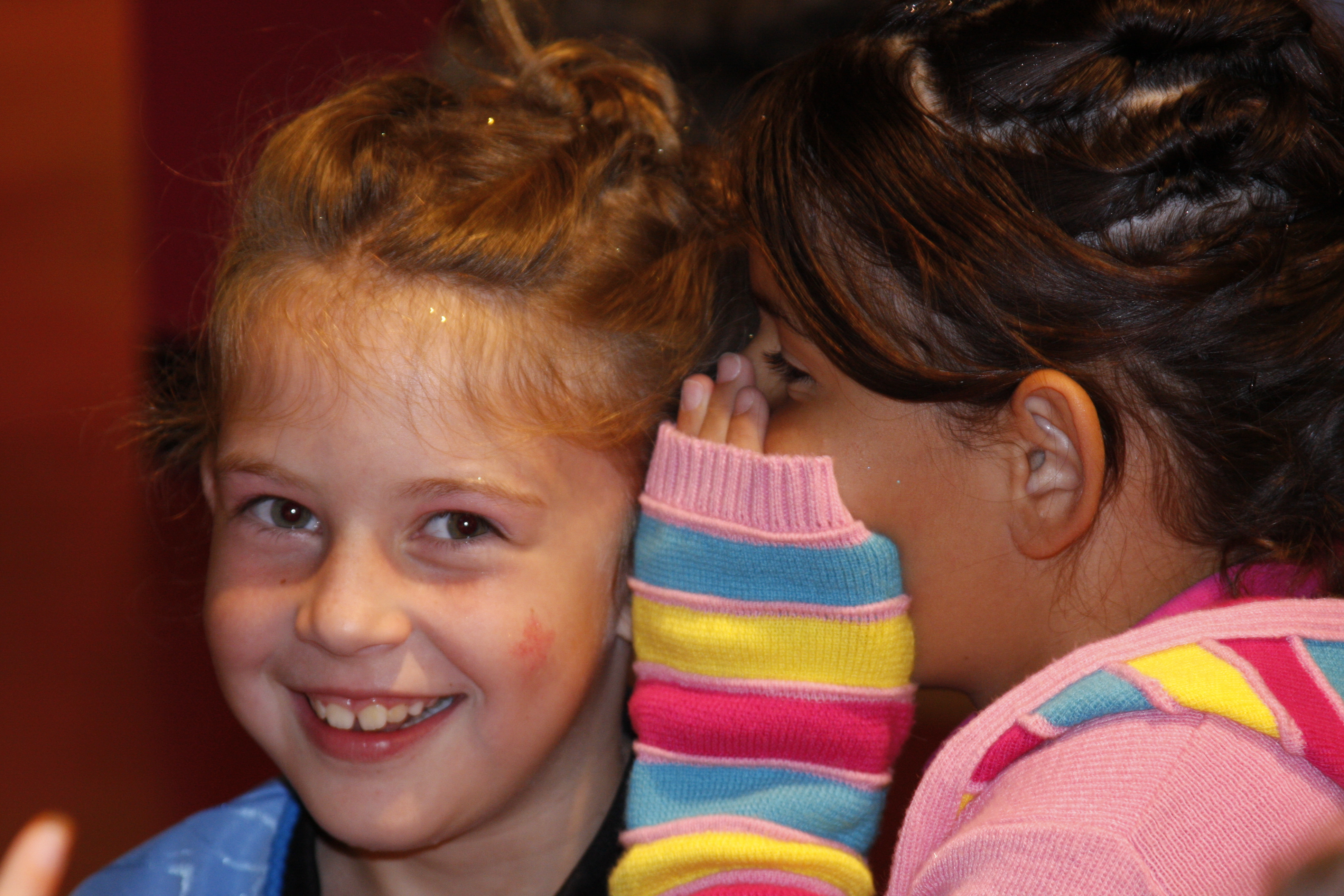 Friends whispering at Sweet & Sassy during kids event